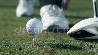 一个高尔夫球手近距离的朝一个点走，在那里他打出一个白色的高尔夫球